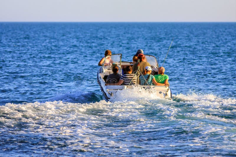 Anapa, Russland - 11. Juni 2012: Leute segeln weg auf Motorboot in hohe See am sonnigen Sommertag Touristischer Transportservice lizenzfreie stockbilder Anapa, Russland - 11. Juni 2012: Leute segeln weg auf Motorboot in hohe See am sonnigen Sommertag Touristischer Transportservice lizenzfreie stockbilder