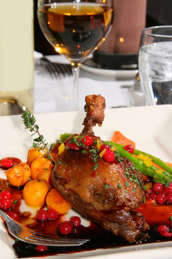 Confit leg of duck on a bed of red currants and roasted vegetables. Confit leg of duck on a bed of red currants and roasted vegetables