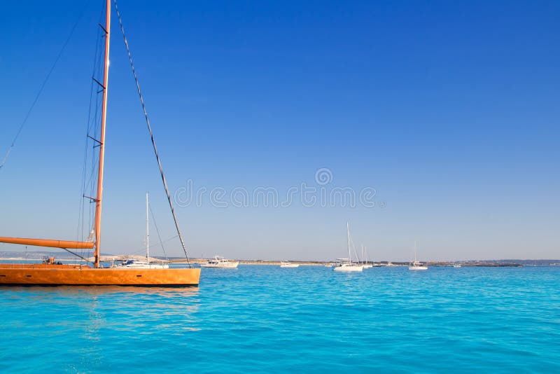 Anchored sailboats in turquoise Formentera beach