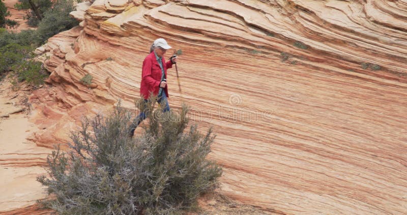 Anciana activa haciendo senderismo en el acantilado de arenisca en zion utah