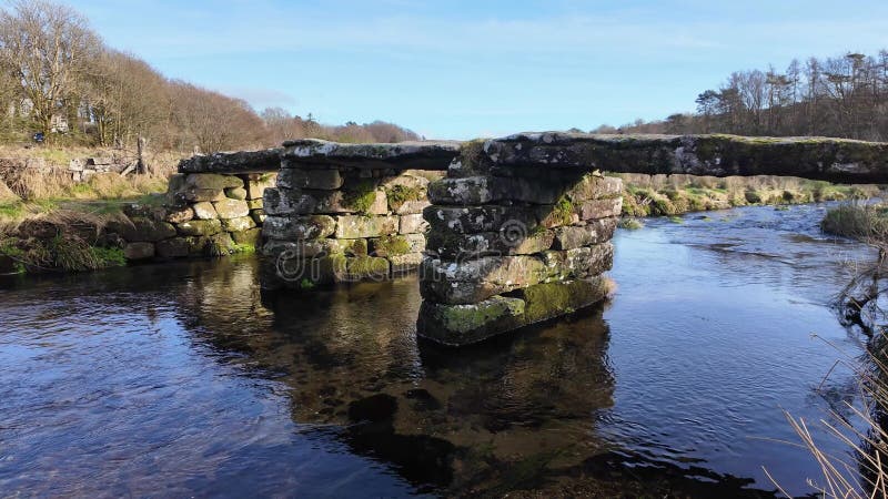 Ancien pont en pierre au-dessus de la rivière à Postbridge sur Dartmoor Devon Angleterre Royaume-Uni. banque de vidéos