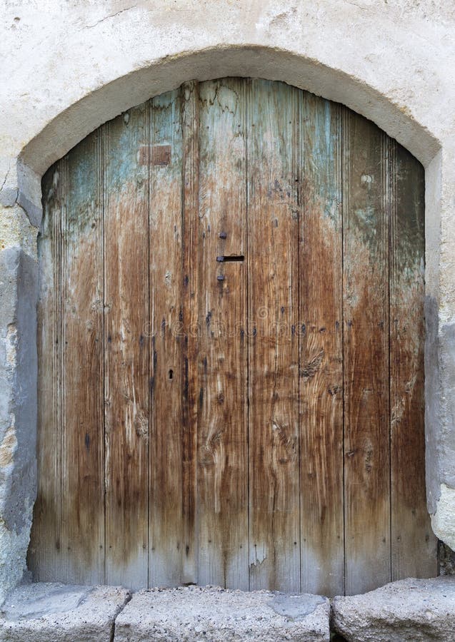 Ancient arched antique wooden doors with a metal lock in the middle royalty free stock photography Ancient arched antique wooden doors with a metal lock in the middle royalty free stock photography