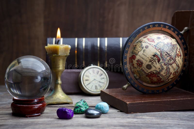 Ancient astrology. Old astrology globe and books with lighting candle