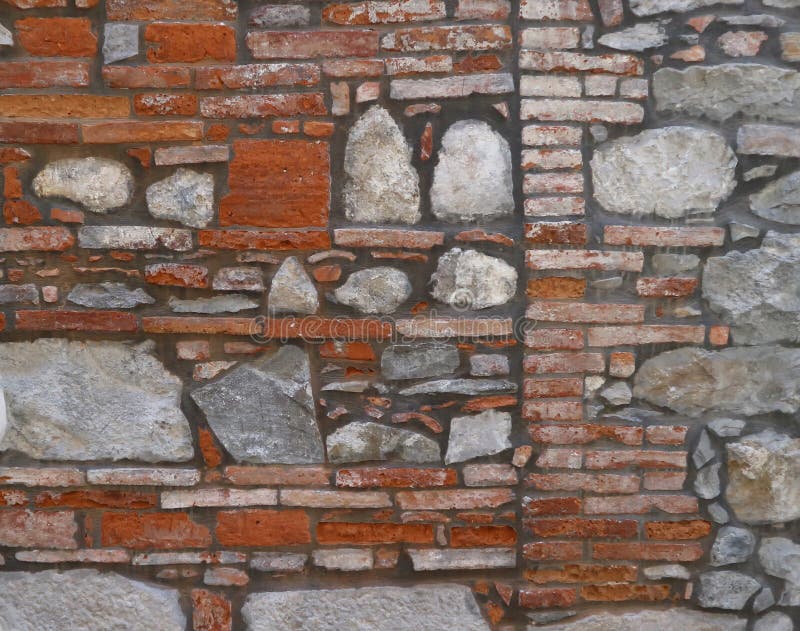 Ancient Brick Wall with Large Stone Blocks Inserted. Stock Photo