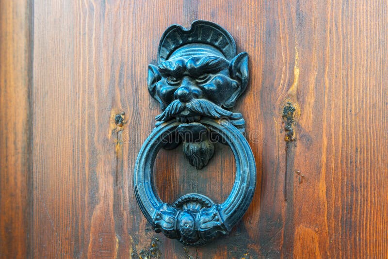 Ancient door knocker on a wooden door in Rome