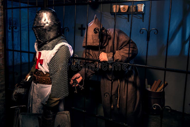 Ancient knight and monk prisoner in castle stock photo