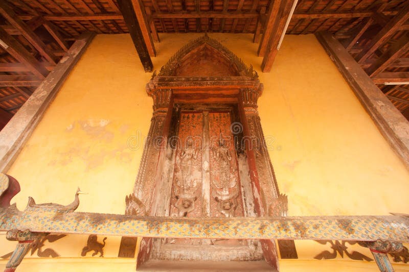 Ancient Laos art wood carving on church in Si Saket temple in Laos.