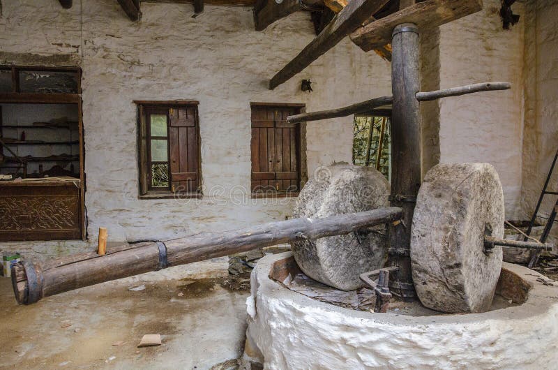 Ancient olive oil production machinery, stone mill and mechanical press, oil mill for olives. Abandoned old grinding stone in Mani