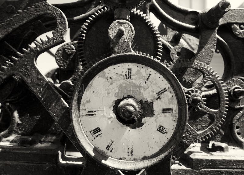 Ancient rusty broken iron clock with weathered face and exposed complex mechanism of cogs and gears royalty free stock photography