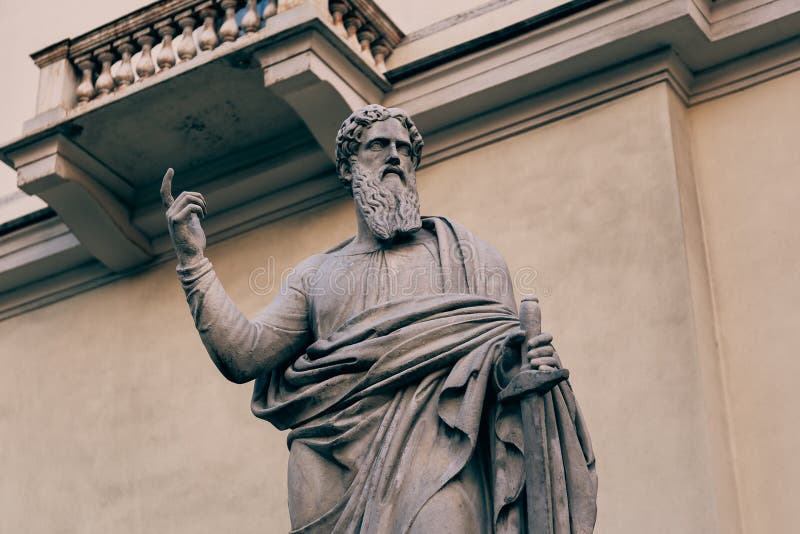 Ancient statue points with index finger at the sky