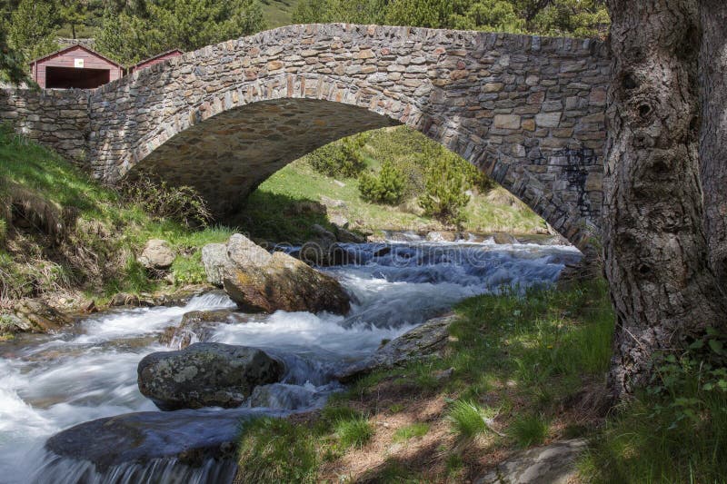 Ancient stone bridge over the Comas river stock image