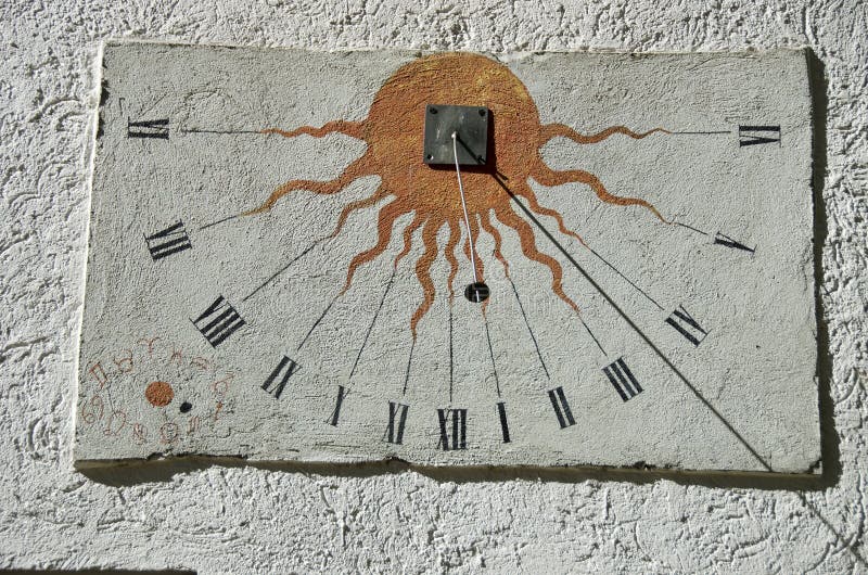Ancient sundial with signs of the zodiac on white wall