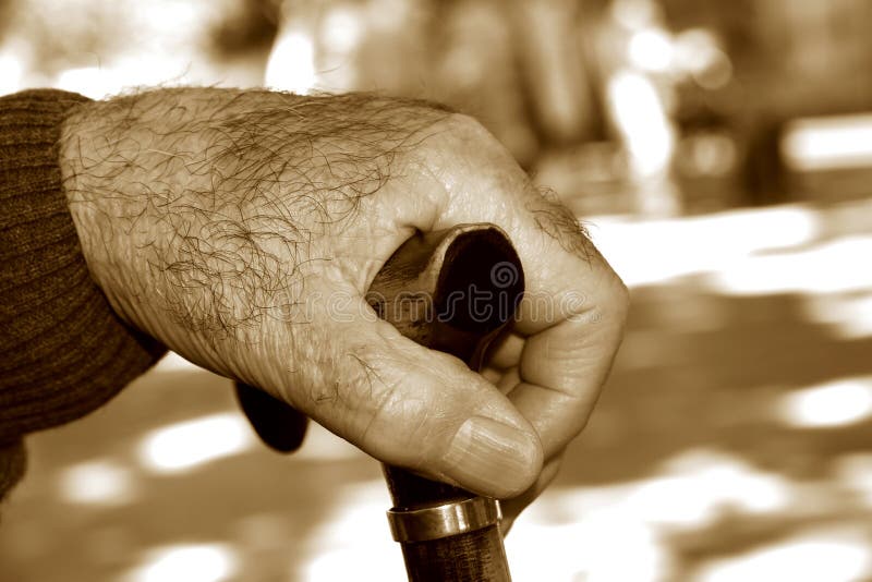 Ancião com uma vara de passeio, na tonificação do sepia
