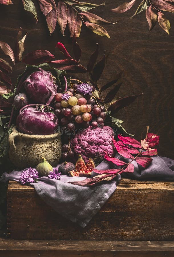 Ancora vita con frutta e verdura viola su tavoli di legno con foglie di cocaina, tovagliolo e autunno Copiare lo spazio per la pr
