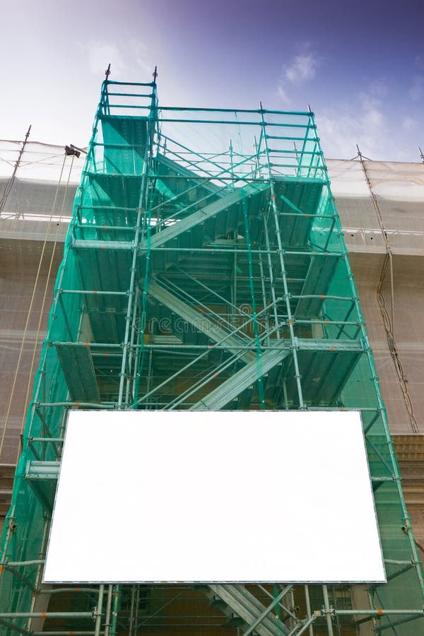 Andaime do metal, com componentes pré-fabricados e o quadro de avisos vazio, para trabalhar na fachada para a renovação da parede imagens de stock Andaime do metal, com componentes pré-fabricados e o quadro de avisos vazio, para trabalhar na fachada para a renovação da parede imagens de stock