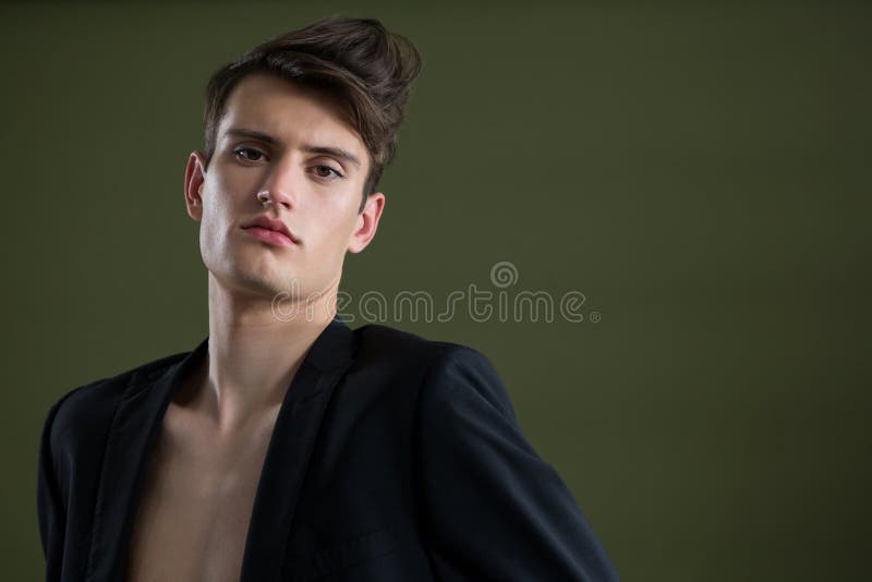 Androgene mens in blazer het stellen tegen groene achtergrond stock afbeelding Androgene mens in blazer het stellen tegen groene achtergrond stock afbeelding