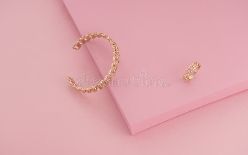 Chain shape Golden ring and bracelet on pink color background. Chain shape Golden ring and bracelet on pink color background