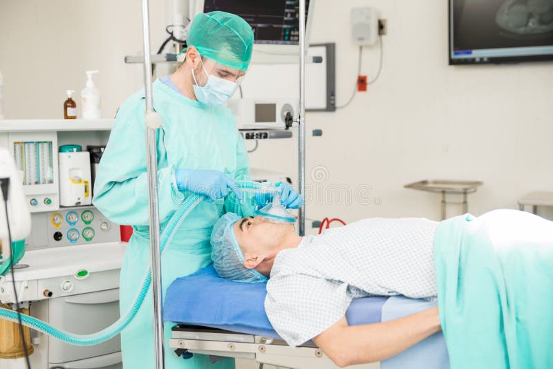 Anesthesiologist die aan een patiënt werken royalty-vrije stock afbeelding Anesthesiologist die aan een patiënt werken royalty-vrije stock afbeelding