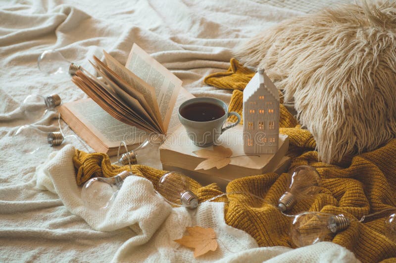 Angaben zum Stillleben im Wohnraum. Pullover und Tasse Tee mit Kerzenschein und Herbstdekor in den Büchern stockfotos Angaben zum Stillleben im Wohnraum. Pullover und Tasse Tee mit Kerzenschein und Herbstdekor in den Büchern stockfotos
