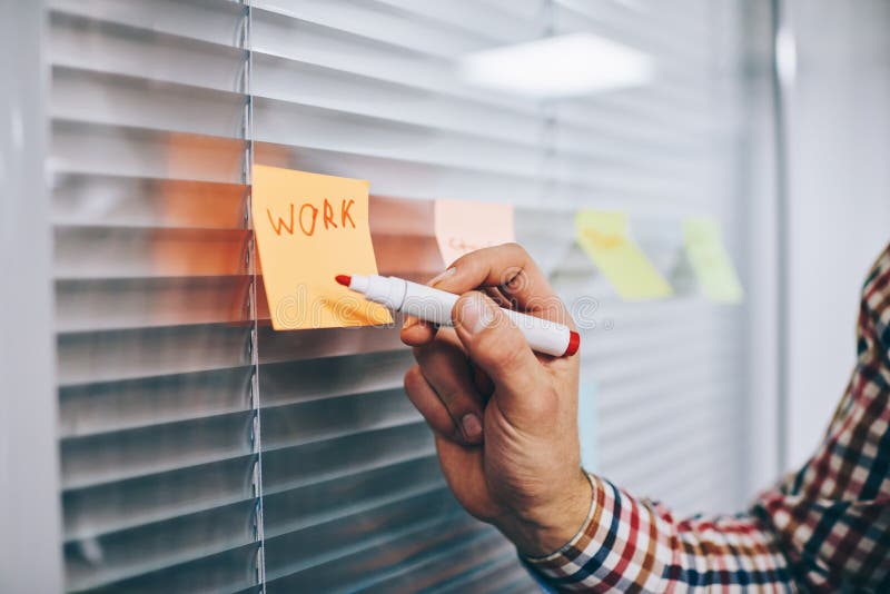 Angajat masculin față care face note pe autocolant stock photos