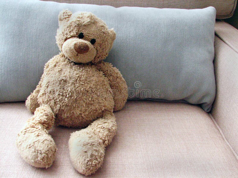 Angefüllter Spielzeug-Teddybär betreffen Couch mit Kissen lizenzfreie stockfotos Angefüllter Spielzeug-Teddybär betreffen Couch mit Kissen lizenzfreie stockfotos