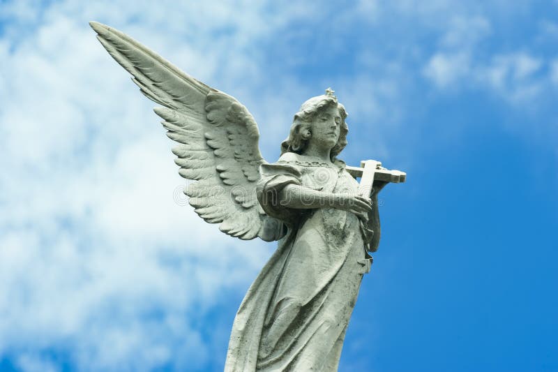 Angel with cross in hands and beautiful wing on Cemetery La Recoleta, Buenos Aires, Argentina