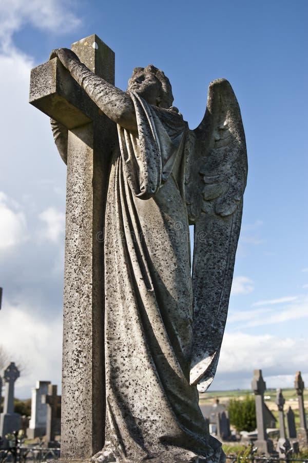 Angel statue embracing a cross and celtic graveyard