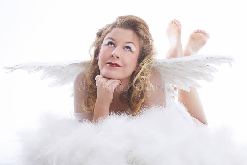 Angelo con le ali. La donna in costume bianco di angelo con le grandi ali si trova su una nube che osserva in su