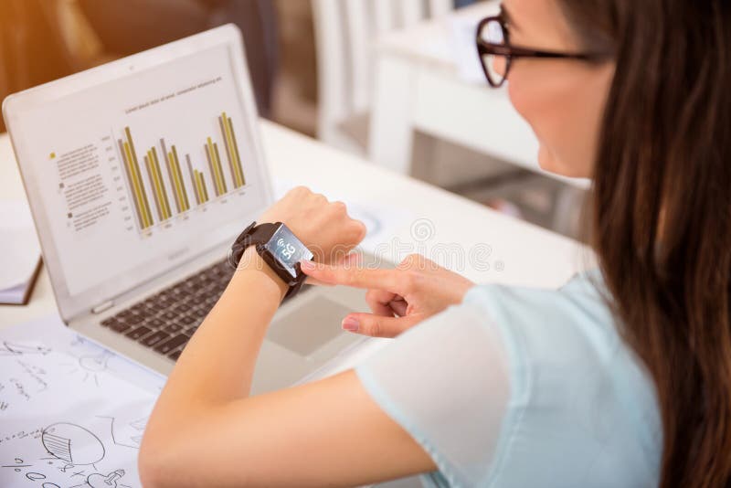 Angenehme Frau, die am Tisch sitzt lizenzfreie stockbilder