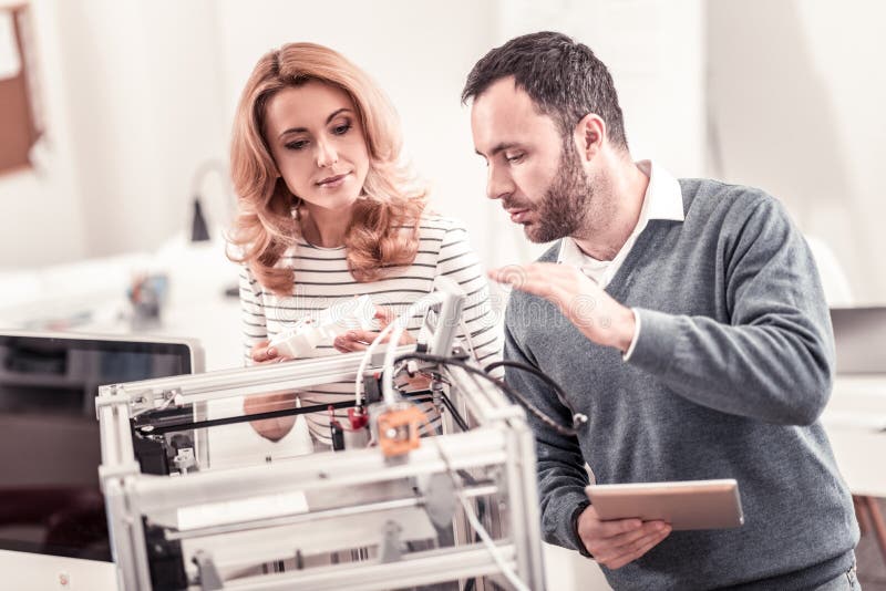 Hardworking people. Pleasant nice men and women creating prototype on 3D printer working all day. Hardworking people. Pleasant nice men and women creating prototype on 3D printer working all day