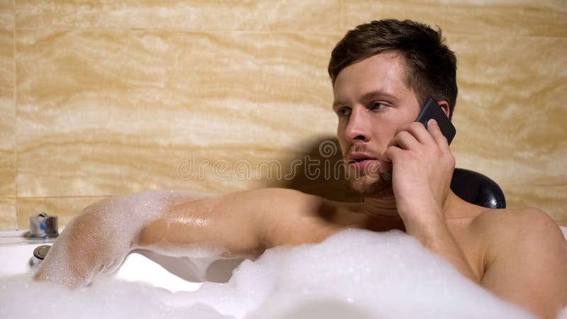 Anger man quarrelling with girlfriend on mobilephone, taking relaxing foam bath royalty free stock photography Anger man quarrelling with girlfriend on mobilephone, taking relaxing foam bath royalty free stock photography