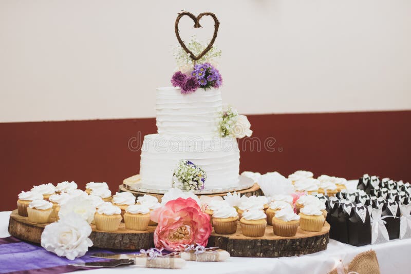 Angeredete Hochzeitstorte und kleine Kuchen lizenzfreies stockbild Angeredete Hochzeitstorte und kleine Kuchen lizenzfreies stockbild