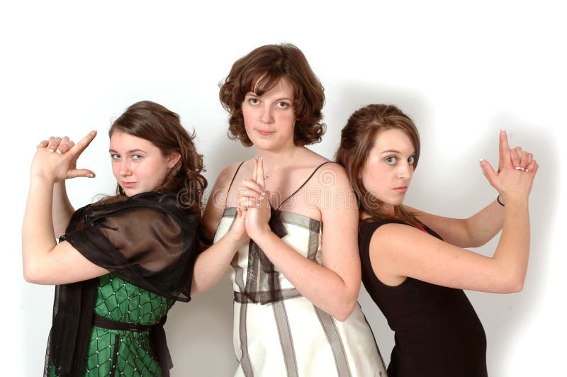 Three teenage girls stirke a charlies Angels pose for fun in their formal attire. Three teenage girls stirke a charlies Angels pose for fun in their formal attire.