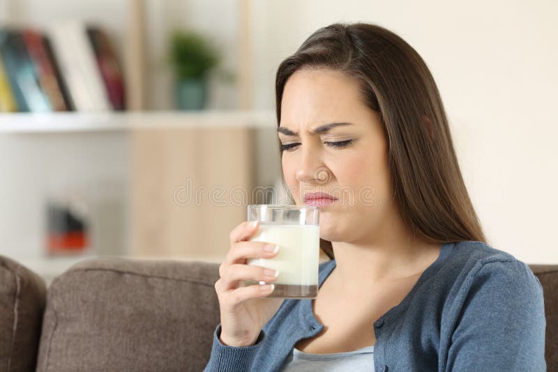 Angewiderte tasing Milch der Frau mit schlechtem Aroma