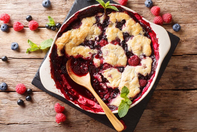 English cuisine: berry cobbler is decorated with mint closeup on the table. horizontal top view from above. English cuisine: berry cobbler is decorated with mint closeup on the table. horizontal top view from above