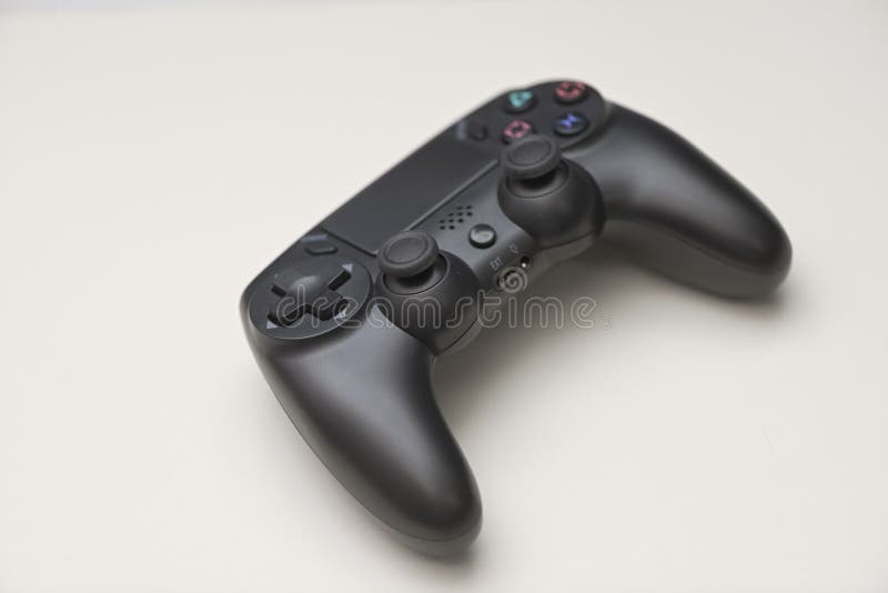 Angled view of black game controller with dual analog joysticks buttons and directional pad isolated on light background royalty free stock images