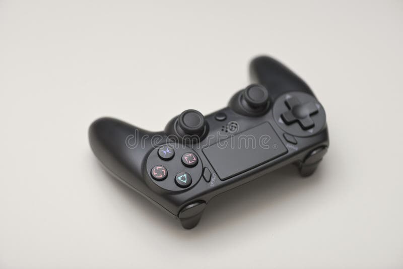 Angled view of black game controller with dual analog joysticks buttons and directional pad isolated on light background stock photo
