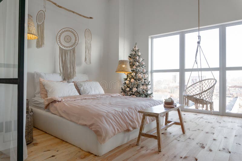 Angolo di visione nella spaziosa camera da letto bianca con grandi finestre decorate con albero di Natale e set da tè fotografie stock libere da diritti