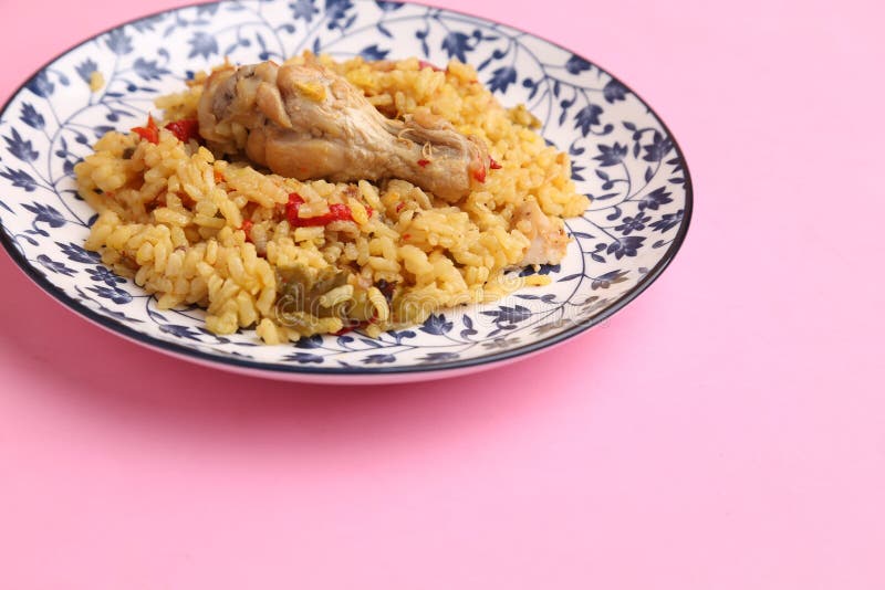 Angolo elevato di un piatto di riso e pollo isolato su uno sfondo rosa immagini stock