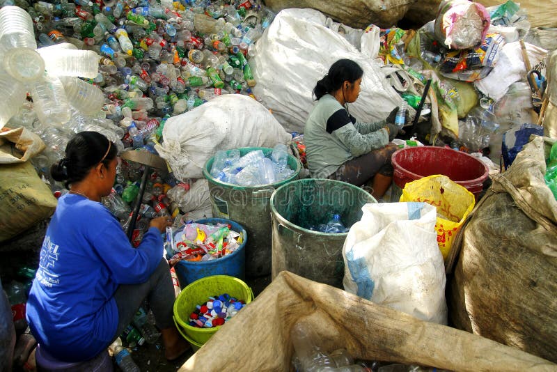 Workers of a materials recovery facility sort through plastic waste and segregate them for proper recycling