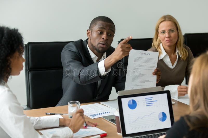 Angry dissatisfied african businessman having claims arguing about bad financial contract terms demanding compensation at diverse business meeting in lawyers office, legal fight and fraud concept. Angry dissatisfied african businessman having claims arguing about bad financial contract terms demanding compensation at diverse business meeting in lawyers office, legal fight and fraud concept