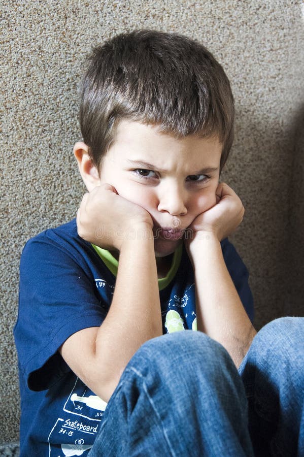 Ein wütendes Kind sitzt in einer Ecke.