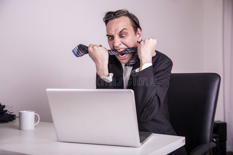 Angry and frustraded business man eating his tie in the office royalty free stock image Angry and frustraded business man eating his tie in the office royalty free stock image