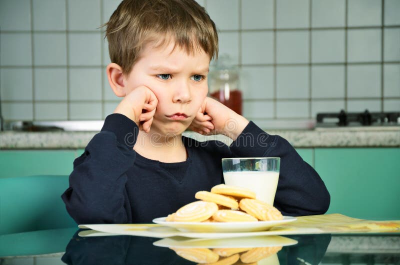 Angry little boy sitting at the dinner table. horizontal stock image Angry little boy sitting at the dinner table. horizontal stock image