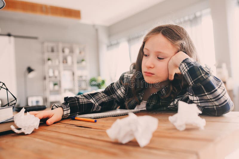 angry and tired child girl having problems with home work, throwing papers with mistakes