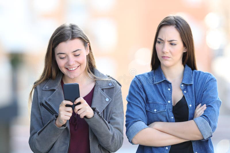 Angry woman with her friend who is using phone