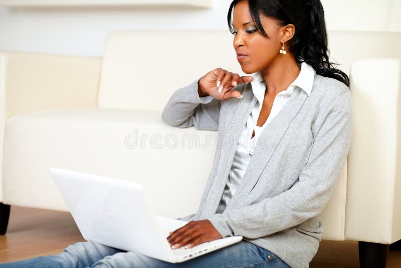 Portrait of a angry woman sitting on the floor in front of her laptop at home indoor. Portrait of a angry woman sitting on the floor in front of her laptop at home indoor