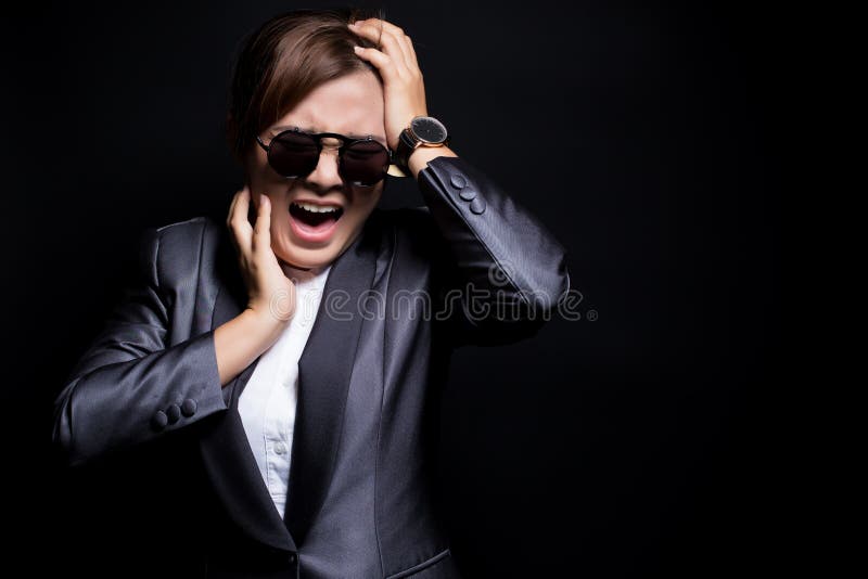 Angry woman wearing sun glasses screaming out and pulling her hair over background