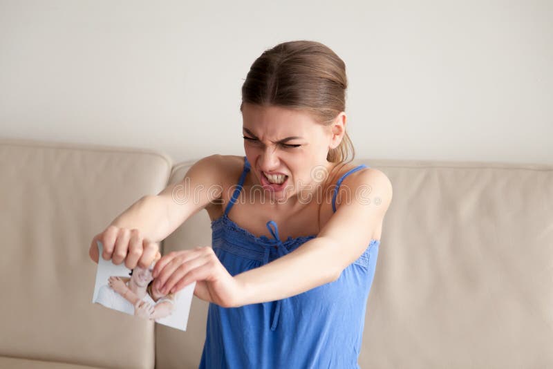 Angry woman tears paper photograph in two pieces stock image Angry woman tears paper photograph in two pieces stock image