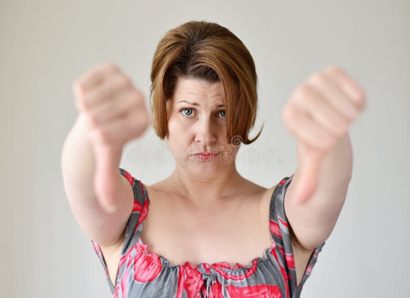 Angry young woman showing thumb down